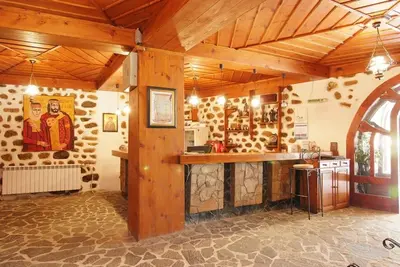 a large room with a kitchen with wooden walls at Despot Slav Hotel & Restaurant in Melnik