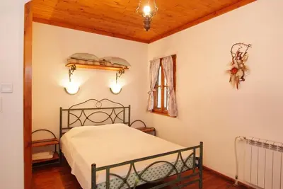 a bedroom with a bed and a wooden ceiling at Despot Slav Hotel & Restaurant in Melnik