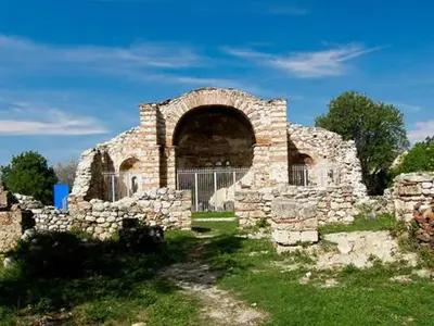 an old stone building with an arch in a field at Despot Slav Hotel & Restaurant in Melnik