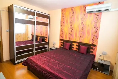 a bedroom with a red bed and a large mirror at Apartment Geo Milev in Plovdiv