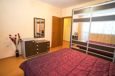 a bedroom with a bed and a dresser and a mirror at Apartment Geo Milev in Plovdiv