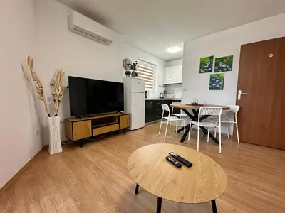 a living room with a television and a table at White Wood Lodge in Bansko