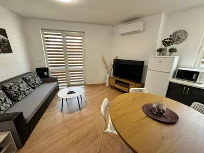 a living room with a couch and a table and a tv at White Wood Lodge in Bansko