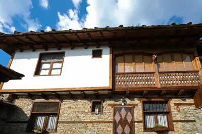 an old building with a balcony on top of it at Тодорината къща in Leshten