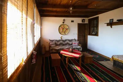 a living room with a couch and a table at Тодорината къща in Leshten
