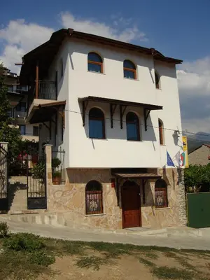 a large white building with windows and doors at Centaur Family Hotel in Rila