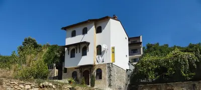 a white building on top of a hill at Centaur Family Hotel in Rila