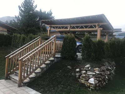 a wooden ramp leading to a garage with a car parked under it at Pirin Golf Villa Emila in Bansko