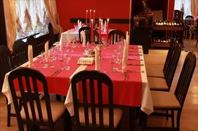 a long table with a red table cloth and chairs at Hotel Real in Plovdiv