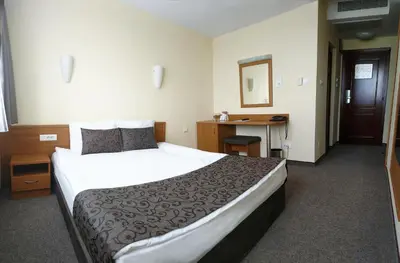 a hotel room with a large bed and a desk at Park Hotel Moskva in Sofia