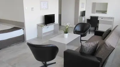 a living room with a couch and chairs and a tv at Park Hotel Moskva in Sofia