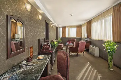 a room with chairs and a table and a mirror at Park Hotel Moskva in Sofia