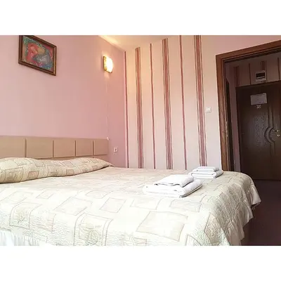 a bedroom with a bed with two towels on it at Семеен Хотел Сокол in Sandanski