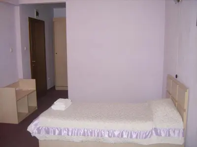 a small bedroom with a bed in a room at Семеен Хотел Сокол in Sandanski