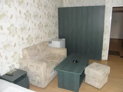 a living room with a chair and a table at Hotel Pilevski in Blagoevgrad