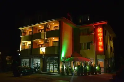 a building with a neon sign in front of it at Hotel Pilevski in Blagoevgrad