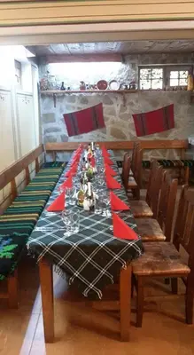 a dining room table with a green and red table cloth at Guest House Todorini kashti in Koprivshtitsa