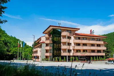 a large building in front of a parking lot at Hotel Park Bachinovo in Blagoevgrad