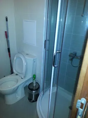 a bathroom with a toilet and a glass shower at Belveder Holiday Club Private in Bansko