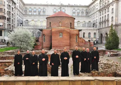 a group of men in black robes standing in front of a building at Ayki - historic centre apartment in Sofia