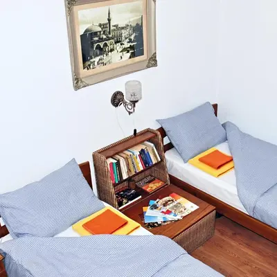 a room with two beds and a table between them at Ayki - historic centre apartment in Sofia