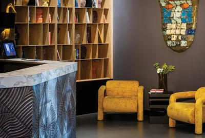 a lobby with two yellow chairs and a counter at Rila Hotel Sofia in Sofia