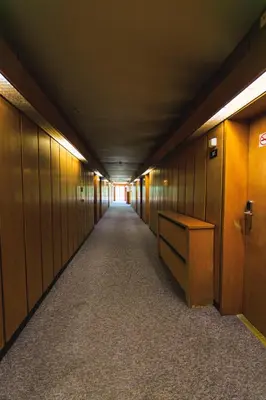 a long hallway with wooden walls and a long hallway with a desk at Rila Hotel Sofia in Sofia