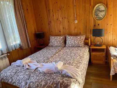 a bedroom with a bed with a bow on it at Вила Мерджан in Sarnitsa