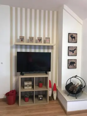 a living room with a flat screen television on a shelf at Papa Moose Pamporovo in Pamporovo