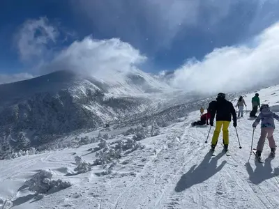 a group of people skiing down a snow covered mountain at Flora Ski-slope Studio Apartment in Borovets