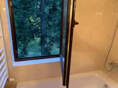a bath tub with a window in a bathroom at Flora Ski-slope Studio Apartment in Borovets