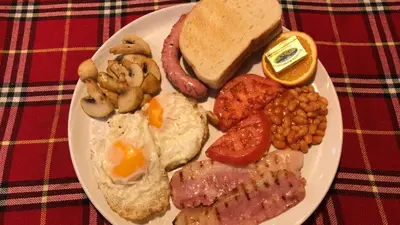 a plate of breakfast food with eggs sausage beans and toast at Flora Ski-slope Studio Apartment in Borovets
