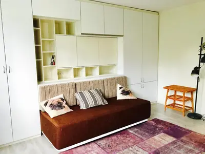 a room with a couch with pillows on it at Modern Studio 20 Meters from Mladost 1 Metro Station in Sofia