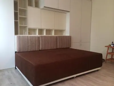 a large bed in a room with white cabinets at Modern Studio 20 Meters from Mladost 1 Metro Station in Sofia