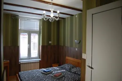 a bedroom with a bed and a window and a chandelier at Stivan Iskar Hotel in Sofia