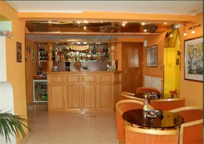 a room with a bar with chairs and a table at Stivan Iskar Hotel in Sofia