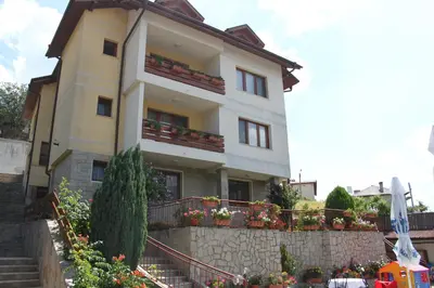 a building with flowers in front of it at Kris Guest House in Devin
