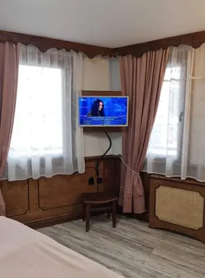 a bedroom with a bed and a flat screen tv at Chuchura Family Hotel in Koprivshtitsa