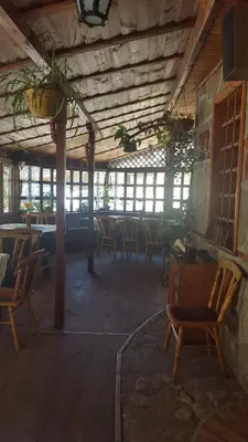 a dining room with chairs and tables and windows at Chuchura Family Hotel in Koprivshtitsa