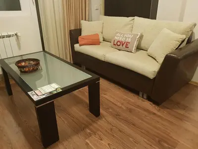 a living room with a couch and a glass table at Katy's studio in Bansko