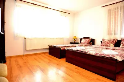 a room with two beds and a chair in it at Guest House Mavrudieva in Koprivshtitsa