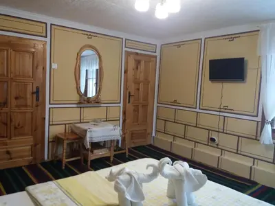 a room with a bed and a tv on the wall at Guest Rooms Bashtina Striaha in Koprivshtitsa