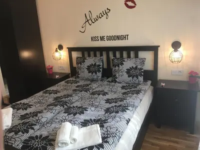 a bedroom with a black and white bed with two pillows at Panorama Apartment Darvenitsa in Sofia