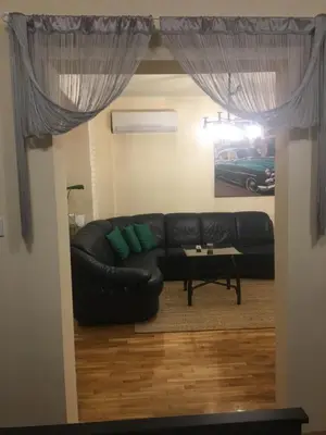 a living room with a black couch and a table at Panorama Apartment Darvenitsa in Sofia