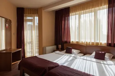 a hotel room with two beds and a television at Family Hotel Gerdjika in Plovdiv