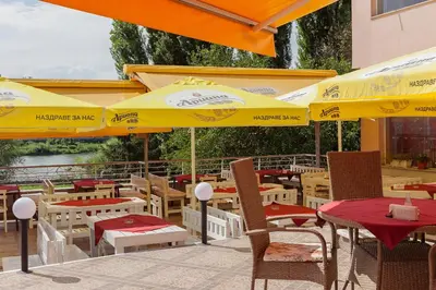 a restaurant with yellow umbrellas and tables and chairs at Family Hotel Gerdjika in Plovdiv