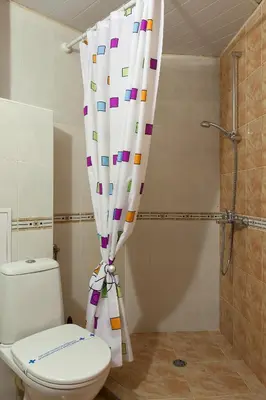 a bathroom with a toilet and a shower curtain at Family Hotel Gerdjika in Plovdiv