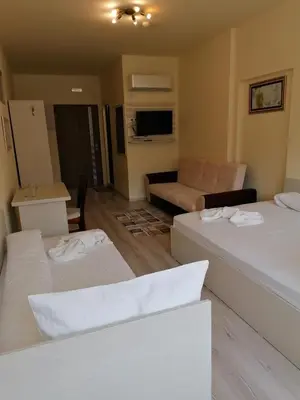 a living room with three beds and a couch at Hotel Lago Peshtera in Peshtera