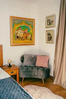 a living room with a couch and a painting on the wall at Rodope Nook Guest house in Chepelare