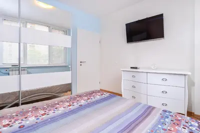 a bedroom with a bed and a tv and a dresser at Comfortable One Bedroom Apartment in a Lively Area | Zona B5 | Russian Square in Sofia